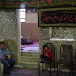 Pie korāna lasīšanas istabas (re, tur iekšā redzams koka statīvs, uz kura liek korānu un sēžas tam priekšā) dežūrē divi jaunēkļi. Laikam nav vēl sasnieguši attiecīgo vecumu.