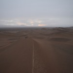 Re, cik smuki no augšas! Teju bezgalīgi tālumā stiepjas vienas vienīgas kāpas! Līdz pat ceļam! Pēc tam tur ir kaut kāds ciems un puskrūmi. Te tā labi nevar saskatīt, bet tas tumšais pleķis kreisajā pusē – tas ir ciems un puskrūmi.