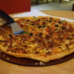 Tālāk mums pienākas lielā pica - pusīte ar liellopu gaļām, kas patiesībā ir ķīniešu cīsiņi (tiem, kas nav bijuši Ķīnā - tas ir tāds izstrādājums, kas izskatās pēc apmēram tā, ko esam pieraduši saukt par cīsiņu, bet ir salds), otra pusīte ar dārzeņiem. Siera vietā, es nezinu. Es nezinu, kā to izstāstīt. Tas nav nekas tāds, ko mans pieticīgais vārdu krājums ļautu precīzi aprakstīt. Un viss, protams, ar pakistāņu garšvieliņām. Tieši tas, no kā mēģinājām aizmukt!