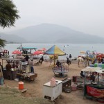 Nonācām kūrortā! Izrādās, ezera otrajā pusē iet vaļā kaut kāda jarmarka. Ļaudis griežas karuseļos, jāj ar zirdziņiem, ēd visādus našķus, īsāk sakot - atkal drausmīgs troksnis un tingeltangeļi. Bet nevaram taču neizpētīt, kā pie ezera atpūšas vietējie.