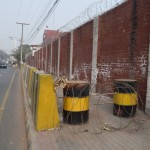 Parādīšu tuvāk - jā, aiz žoga droši vien ir kaut kāda svarīga militāra vai valsts pārvaldes ēka, bet man kaut kā šķiet, ka ar četrmetrīgo žogu un vienu dzeloņstiepļu virteni tam pa augšu būtu pilnīgi pieticis. Tagad sanāk tā, ka visiem kājām gājējiem labus dažsimt metrus jāiet pa brauktuvi, un brauktuves Lahorā galīgi nav tās drošākās vietas, pa kurām pārvietoties. Ā, par šo bildi, starp citu, saņēmu puteni no bruņota sarga, nedrīkst taču bildēt apkārt tā, kur vien gribas.