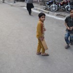 Mazie puikas mācās spēlēt kriketu. Īstas nūjas, protams, viņiem nav, tāpēc jāiztiek ar to, ko var atrast zemītē - dēļa gabalu. Turklāt šodien pa lielo ielu nebrauc mašīnas, kriketot var uz nebēdu! Nav jau arī, ka viņi nemētātu bumbu arī uz ielām, kurā satiksme nav novākta.