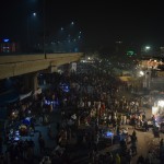 Uzkāpām uz metro tilta (Lahoriešu izpratnē metro ir autobuss, kurš brauc pa augšu pārējai pilsētas satiksmes, nevis tas, ko mēs esam pieraduši saprast ar metro), un, lai gan no šejienes bildēt neko nedrīkst, bruņotie sargi saka, ka, tā kā esam viesi, pāris bildītes tomēr uztaisīt varam. Nu, lūk, tā apmēram izskatās festivāla publika. Viss rajončiks slēgts, un visas tuvējās ielas pārpildītas ar svētceļniekiem. Protams, festivāla ietvaros notiek arī daudz nopietnākas lietas, nekā tās, ko rādīju, piemēram, publiskās korāna deklamēšanas un līdzīgas izdarības, bet tas lai paliek citai reizei. Šoreiz centāmies izbaudīt festivāla dullāko aspektu, babas un tā.