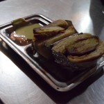 Tā, vēlu vakarā esam nokļuvuši Amritsarā un ieturam pirmās indiešu vakariņas. Tā kā Amritsara ir sikhisma piekritēju neoficiālā galvaspilsēta, šeit viss (vismaz vecpilsētā) pakārtots sikhu izpratnei par lietām - galvenā (zelta) tempļa tuvumā aizliegta ne tikai gaļas patērēšana (pat McDonaldā visi ēdieni ir veģetāri!), bet nevar būt ne runas arī par alkohola lietošanu vai smēķēšanu. Tā kā no otrā netikuma joprojām neesam atbrīvojušies, savas nezināšanas dēļ dabūjām puteni (patiesībā vairāk tādu kā aizrādījumu) no kāda vietējā - kamēr mēs izbrīnīti ar cigareti zobos stāvējām teju simt metru attālumā no tempļa, kāds vīriņš mums pacietīgi un iejūtīgi skaidroja - šeit nedrīkst. Paejiet pārsimt metru tajā virzienā un varat pīpēt uz nebēdu. Pat neliek nodzēst cigaretes! Pirmie iespaidi par Amritsaru un tādējādi Indiju vispār patiesībā ir diezgan pozitīvi, bijām gaidījuši kaut ko daudz nejaukāku. Bet atgriežoties pie attēlā redzamā brīnuma - lai gan izskatās pēc cietuma virtuves paraugstundas, patiesībā tas ir ārkārtīgi garšīgs (beigās izrādījās teju garšīgākais, ko Indijā nācās baudīt) burgeris ar kartupeļu kotleti un divām dažādām mērcītēm. Ciparu mīļotājiem - izmaksāja apmēram 60 centu gabalā.