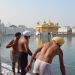 Bariņš sikhu gatavojas svētajai apmazgāšanās procedūrai, šeit var novērot vēl vienu no sikhiem svarīgajiem pieciem K - Kačeru. Kačera ir kokvilnas apenītes, kuras jāvalkā katram sikham, arī sievietēm. Parasti tās tiešām tiek valkātas kā apakšbikses, bet, ja laukā ir tiešām karsti, Kačera var tikt izmantota arī kā šorti. Tāda priekšrocība tiek dota tikai kungiem, dāmām gan jāpiesedzas rūpīgāk. Kungs baltajos šortiņos gan mazliet grēko, jo viena no Kačeras pamatidejām ir tāda, ka tā ir pietiekoši plata un personīgo anatomiju nosedzoša, kas šajā gadījumā nav izdevies caurspīdīguma dēļ. Ja jau runājam par pieciem K, pie reizes nosaukšu arī pārējos: Kešs (garie mati un bārdas, kurus, kā jau minēju, aizliegts apgriezt, lai neaizskartu dieva jūtas), Kanga (koka ķemmīte, kas vienmēr jānēsā matos/turbānā, un divas reizes dienā higiēnas apsvērumu dēļ ar to jāizķemmē visi mati un bārdas. Starp citu, arī turbāns katru dienu jāuzsien no jauna, to nedrīkst vienkārši noņemt un uzlikt kā tādu cepuri - atkal higiēnas apsvērumu dēļ), Kara (aproce, kas vienmēr jānēsā uz roku, lai atgādinātu sev, ka visam, ko tu dari ar savām rokām, ir jābūt saskaņā ar Guru dotajiem norādījumiem), Kačera (jau minētās apenītes, kuras mūsdienās ne ar ko daudz neatšķiras no parastām lielveikala apenēm, bet senajos laikos bija visai neparasts apģērba gabals, paredzēts tam, lai sikhs būtu vienmēr gatavs cīnīties, jo parastās, viena auduma gabala apeņu uzvilkšana aizņēma pārāk daudz laika, bet pliks taču cīnīties nevar!) un Kirpans (duncis, kuru kārtīgam sikham vienmēr jānēsā līdzi, bet tas paredzēts tikai aizstāvēšanās vajadzībām, uzbrukt ar to nav ļauts. Aizstāvēšanās gan var nozīmēt arī citu cilvēku aizstāvēšanu, un tādējādi - uzbrukumu trešajai personai. Starp citu, katra sikha svēts pienākums ir iztaisnot visas pamanītās netaisnības, ja sikhs redz uz ielas kādu vardarbības vai citas netaisnības momentu, viņam obligāti jāiejaucas un viss jāvērš par labu. Dažas Āzijas aviokompānijas pat ļauj sikhiem kāpt lidmašīnā ar mazajiem nazīšiem pie jostas).