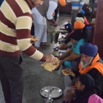 Viss notiek ļoti ātri un organizēti - tikko iepriekšējie ēdāji pamet zāli, iekšā ielaiž pāris simtus jaunu ēdāju, visi smuki sasēžas līnijās, katram izsniedz metāla šķīvīti (paplāti?), tad garām staigā vīri, kas izsniedz pārtiku - pirmais atnes maizi, otrs nāk ar dāla (lēcu putra) spainīti, katram ielej pa kausiņam, trešais nāk ar vēl kaut kādu dārzeņu sautējumu, ceturtais atnes padzerties ūdeni. Un ēst drīkst/pienākas tik daudz, cik katrs vēlas, tikko šķīvis tukšs, tas tiek papildināts ar jaunu ēdienu.