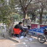 Beidzot pienākusi TĀ diena, esam saņēmuši savas ar Indijas vīzām piepildītās pases no Gerry's, pēdējā darbalaika stundā pamanījušies vēl atskriet līdz Imigrācijas dienestam, kurš mums sola, ka, ja visus dokumentus iesniegsim laicīgi, tas ir šodien, līdz piektdienai pases ar pagarinātajām Pakistānas vīzām būs atpakaļ un varēsim legāli pamest valsti. Problēma tā, ka nezinājām pilno nepieciešamo lietu sarakstu - vēl vajag divas pases kopijas (labi, ka turpat pie biroja šādām vajadzībām sēž kopētājvīriņš (attēlā), kurš savu multifunkcionālo ierīci darbina no visparastākā automašīnas akumulatora (!)), un divus pases izmēra fotoattēlus ar zilu (!) fonu. Pasu vīrs mums izstāsta, kur un kā jāskrien, lai dabūtu vajadzīgās fočenes, un apsolās pagaidīt un savu bodīti ciet neklapēt, kamēr neatgriezīsimies. Mīļums!