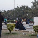 Bet kāpēc vispār par šo laukumu sāku runāt - piesēdām šeit atvilkt elpu, jo šī bija vienīgā vieta apkārtnē, kur vispār var piesēst, un, kas nav pārāk piemēslota. Un, tikko bijām piesēduši, mūs momentā apsēda neskaitāmi biznesmeņi - apavu tīrītāji, apavu remontētāji, visa kā pārdevēji, vienkārši ubagi, bet no šiem visiem pamatīgi izcēlās viens - kungs sarkanajā micītē apmēram attēla vidū. Tuvāk viņu nepaspēju nobildēt, jo šoks. Izstāstīšu, kāpēc šoks - vīrs mūs uzrunāja, noskaidrojis, ka runājam arī krieviski, piedāvāja paskatīties savu "gestbuku" - mazu blociņu, kur iepriekšējie klienti atstājuši atsauksmes, visas, protams, superpozitīvas. Pakalpojums, ko vīrs piedāvā, ir ausu tīrīšana. Likās pietiekami ņirdzīgi, tāpēc domāju - kāpēc neizmēģināt. Prasu, cik maksā, vīrs saka, ka sākumā jāpārbauda ausu netīrības pakāpe. Tā kā esmu obsesīvs ausu tīrītājs, zinu, ka nekādas šmuces manās ausīs būt nevar, bet, nu, labi - inspicē, vīrs! Aizdomas sāka rasties, kad vīrs palūdz atvērt muti - protams, uzreiz bail, ka kaut ko man tur sabakstīs pārāk dziļi, kaut ko satraumēs, tāpēc saku, ka tas jau par traku, pakalpojumu neizmantošu, paldies. Bet - nekā, vīrs man saka, ka viss ir slikti, obligāti jātīra ausi, ja neticu, lūk, vatīte, lai pārbaudu pats. Un iebāžot vates pikuci ausī, sajūtu, ka tur tiešām kaut kas ir, izvelku - brūna, ķipīga masa. Bet es ZINU, ka pirms tam tur nekā tāda nebija. Iztīrīju šmuci, cik nu spēju un mudīgi notinos. Tātad shēma tāda - vīrs piedāvā iztīrīt ausi, pārbaudes laikā to piešmucē, radot vajadzību pēc pakalpojuma, un tad par naudiņām pats savu šmuci iztīra. Šis piedzīvojums, manuprāt, ļoti labi demonstrē visu mūsu Indijas piedzīvojumu - visneiedomājamākie krāpniecības veidi, lai tikai tiktu pie kādas kapeikas. Godīgi sakot, šo kungu es attaisnoju - lai izdomātu kaut ko tik absurdu, jābūt pietiekami radošam, hehe.