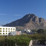 Tāds, lūk, skats no mūsu izvēlētā hosteļa terasītes. Izskatās bišķiņ pēc Gibraltāra. Un te, uz terasītes, parādās mana nākamā Indijas problēma - apgarotie bālģīmji. Tā kā joprojām ir agrs rīts, jaunās, skaistās Eiropietes pa vienai sāk ripot ārā no savām istabiņām ar padusē pasistiem tepiķīšiem un sāk sirsnīgi jogot/meditēt. Nepadomājiet, ar jogu un meditāciju man nav itin nekādu problēmu, tās ir pat ļoti atbalstāmas nodarbes. Bet pretenciozi tikko tīņu vecumu pārkāpuši bālģīmji, kas par vecāku nopelnīto naudu ieradušies Indijā meklēt sevi (turklāt sevi meklē pēc iespējas komfortablākā un ar visām ērtībām aprīkotā viesnīcā, ieteicams, kādā no "svētajām" pilsētām), tie gan man neiet pie sirds. Atgādināšu vēlreiz - joga, meditācija ir ĻOTI atbalstāmas nodarbes. Pat, ja to praktizēšanai man nesaprotamu iemeslu dēļ speciāli tiek veikts garais ceļš līdz Indijai. Bet tie pretenciozie jaunieši, grrrr...