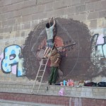 Te jaunēkļi zīmē uz sienas muzikantu. Vispār sienas no vienas vietas nokrāsotas un nozīmētas, bet visi tie grafiti ir salīdzinoši skaisti. Nu, nav tādi "Ja zģes bil" variantu. Drausmīgi daudz arī uzņēmumu reklāmiņas, tādas kā dzeltenās kreisajā pusē. Dažas izskatās desmitiem gadu vecas un, šķiet, vispār vairs nav aktuālas.