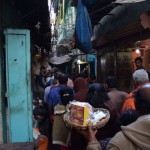 Nākamais stāsts ir par Višvanata templi. Šie visi ļaudis stāv rindā uz drošības pārbaudi, jo tās šeit ir diezgan stingras - nedrīkst ņemt līdzi ne somas, ne fotoaparātus, ne šķiltavas, neko, neko. Tikai pasi drīkst, bez pases ārzemnieks nemaz netiek pielaists templim tuvumā. Mēs, protams, noskopojāmies un turpat biznesu uzsākušos mantu glabātājus noignorējām, tā vietā uz templi ejot maiņās - viens sargā mantas, otrs iet skatīties. Izstāstīšu par savu apmeklējumu - pēc pirmās drošības pārbaudes mani ieaicināja atsevišķā militāristu/policistu telpā, kur jāiesniedz pase, jāatstāj apavi un jāaizpilda forma, kurā jānorāda mājas adrese, vecāku vārdi un citas privātas lietas. Pēc formalitāšu nokārtošanas eju uz templi, bet - tavu nelaimi - kāds vietējais vīriņš norāda uz zīmi, kas saka, ka nehinduistiem iet templī aizliegts. Nu, neko darīt, lai nu cik maz, tomēr cieņa pret reliģiju saglabājusies, tāpēc bēdīgs par iztērēto laiku un nerviem eju pie zaldātiem pēc kedām. Bet, pag, pag, mani aptur tas pats vīriņš, saka, lai eju pie vēl cita vīriņa, tas varot visu nokārtot. Mazliet aizdomīgs eju pie nākamā vīriņa, kurš saka, ka par piecdesmit rūpijām varot man pārdot ziedojuma komplektiņu (spainītis ar puķēm un kaut kādām jocīgām bonbongām, ko hinduisti parasti atstāj pie dieviņu tēliem tempļos), kas mani automātiski padarīs par hinduistu, un es varēšu iet templī! Es, neraksturīgi sev, sacēlu haosu, sāku uz visiem kliegt, lamāt viņus un viņu morāli. Kā tas ir?! Par piecdesmit rūpijām varu kļūt par hinduistu un iet viņu svētākajās vietās?! Cik augstu viņi vērtē svētumu un cik naudu? Man reliģijas vispār šķiet aplams koncepts, bet parasti cienu ļaužu izvēles sekot un ticēt tam, kam vien viņi vēlas, bet, ja šie mantkārīgie idioti ir gatavi pārdot savu reliģiju par 50 rūpijām (atņem vēl spainīša pašizmaksu un tur pat pusdienas nesanāk), tad kas paliek pāri? Nē, sjo, man nav vairs nekādas cieņas ne pret Indiju, ne hinduismu. Variet mani zākāt par aizspriedumainu, neiejūtīgu un vispār absolūti neiecietīgu, es pēc pārdzīvotā tāpat vairs viedokli nemainīšu, haha. Pēc tam atvainojos policistiem/zaldātiem par izraisīto scēnu, uzvilku kediņas, paņēmu pasīti un gāju sūdzēties Karīnai.