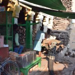 Aiz cieņas pret reliģiju un aizgājējiem, neko no tā, protams, nesabildēju. Pa tumsu vēl kaut kā var, bet dienas laikā paties’ nekādi neceļas roka. Bet re, varu parādīt, kā notiek tirgošanās par malku. Vīriem ir visdažādākā - sākot ar sandalkoku (visdārgākā un labākā) un beidzot ar skaidu plati un kaut kādiem veciem šīfera gabaliem. Par pēdējiem, protams, samelojos, bet vispār izvēle ir liela, jebkura rocībai atradīsies kaut kas ģeldīgs. Tā nu lūk tuvinieki sarēķina, kas un cik sanāk, nosver, samaksā naudiņas un tālāk visu jau nodod "neaizskaramajiem", kuri parasti ir tie, kas visu procesu sakārto.