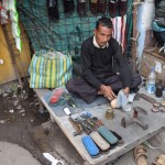 Pastāstīšu labāk arī par kādu labu cilvēku. Šāds te kurpju vīriņš sēž izklājis savu deķīti zemītē un remontē kurpes. Manām Palladium kedām beidzot notikusi nelaimīte - pušu papēdis. Iedomājies - jau deviņus mēnešus velku tos apavus katru dienu! Esmu nostaigājis vismaz kādus pāris tūkstošus kilometru ar tiem, bet tikai tagad pirmais caurums! Turklāt es nejēdzu staigāt - parasti man visādas Converse un līdzīgas kedas pietiek kādiem trim mēnešiem, un tas ir strādājot birojā un staigājot gandrīz tikai līdz tramvajam un atpakaļ (pārspīlēju), bet šīs pietika deviņiem mēnešiem īstas ceļošanas!!! Turklāt caurums izplīsis arī tikai tāpēc, ka es esmu pārāk slinks, lai katru reizi atsaitētu un aizsaitētu kedas - velku tās nost ar otras kājas papēdi un valku virsū stipri velkot aiz mēlītes. Labi, par savām brīnumainajām kedām esmu palielījies, gribu atgriezties pie vīriņa - par visu šūšanu, līmēšanu un ko tik vēl ne vīriņš paprasīja tikai 30 rūpijas! Iedevu viņam piecdesmit! Tāds godīgs kungs ir nopelnījis!