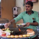 Paskat, kādi šim vīram burgeri! Pilni ar tomātiem! Nevaru laist garām iespēju pamieloties ar tādu. Protams, beigās izrādās, ka pārdošanai pagatavotie burgeri ne tuvu neizskatās tādi, kā apskatei izliktie paraudziņi, bet neko jau indietim nevar pārmest - viss McDonalds un līdzīgu iestāžu labākajās tradīcijās, tikai fočenīšu vietā nolikta īstā štelle. Starp citu, šādi tomātaini burgeri izkārtoti viscaur pilsētai, pie visiem burgeru cepējiem, līdz ar to arī konkurence neļauj tādus neizvietot. Kurš tad iepirksies pie burgeru vīra ar tādiem pavisam bēdīgiem, beztomātainiem paraudziņiem!