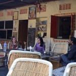 Pēc neskaitāmām sazvanīšanās reizēm Katiņu un viņas mītni atrast tomēr izdodas, urā! Katiņa, tātad, savās skolas brīvdienās dzīvo mītnē, ko dēvē par "Sukhas Place". Attēlā redzamais kungs labajā pusē ir pats saimnieks, vārdā Sukha. Re, kāda viņam gara bize! Varbūt ātri izstāstīšu vēl mazliet par Katiņu - viņa pirmo reizi ieradās Indijā pirms pieciem gadiem, te viņai ļoti iepatikās, tāpēc izlēma, ka "Turības" vietā var tūrismu studēt arī Indijā, izmaksas ir līdzvērtīgas, diploms gan jau pat vērtīgāks un tā. Tā nu viņa te dzīvo vēl šobaltdien. Viņa dažas nākamās dienas būs mūsu Indijas mentors, iemācīs visu, kas un kā.